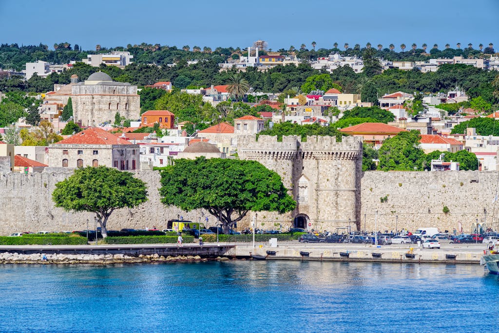 Beautiful view of the historic fortress in Rhodes, Greece, with vibrant cityscape and waterfront.