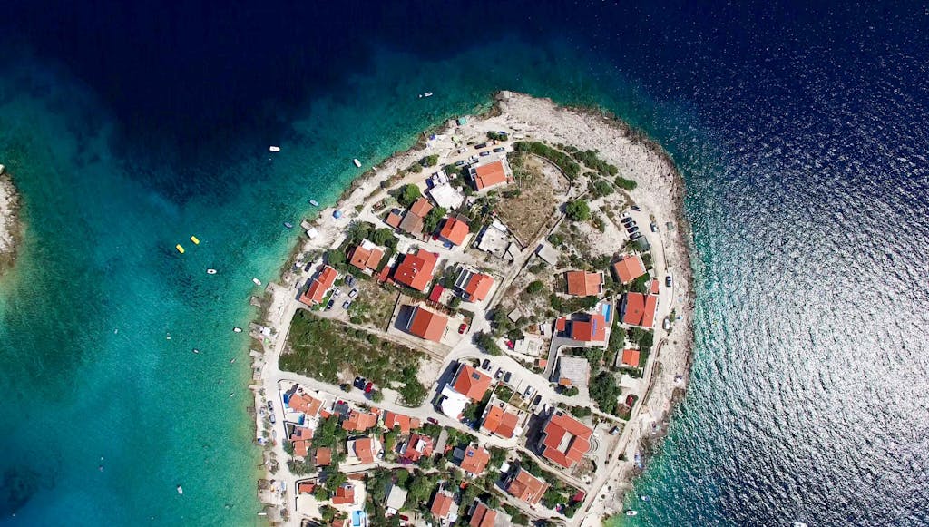 Discover this stunning aerial view of a Croatian seaside village surrounded by crystal-clear waters.